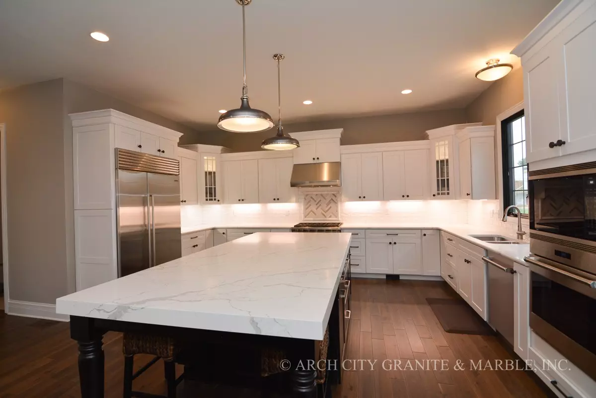 https://www.archcitygranite.com/wp-content/uploads/2017/05/Quartz-Countertops-with-two-tone-kitchen-cabients.jpg.webp